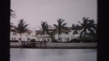 Dade County Florida (1955): A Boat Driving Past Homes On The Ocean During A Day