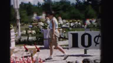 Dade County Florida (1955): Short Haired Woman Browses Outdoor Rummage Sale In The
