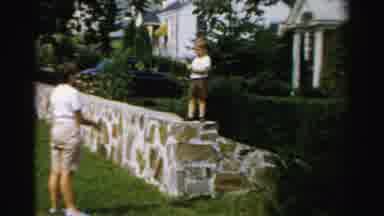 ALBANY NEW YORK-1955: Two Boys Play In Backyard As Man Makes Faces At Camera