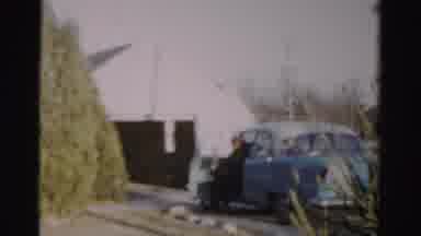 Albany New York (1955): Man Wearing Black Coat Gets Out Of Blue Car While Kids Run
