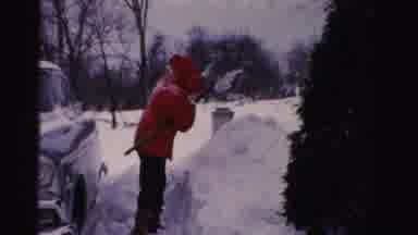 Albany New York (1955): Person Wearing Red Jacket Shovels Snow From Car On A Clear