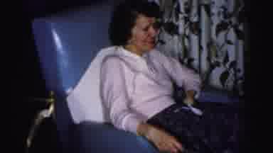 Albany New York (1955): Woman Sitting In Blue Chair Watching Others Fix Something