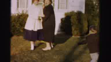 Albany New York (1955): Woman Wearing Brown Coat Stands In Front Of A White House