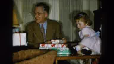 HICKSVILLE NEW YORK-1956: Little Girl Climbs On Table To Reach Wrapped Presents
