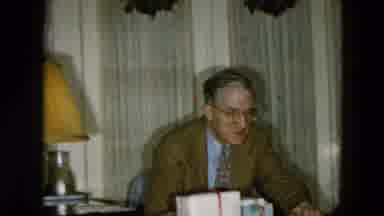 Hicksville New York (1956): Man With Glasses Sits At Table Near Presents Little