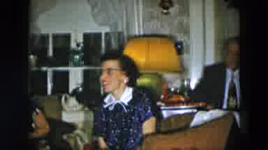 Hicksville New York (1956): Girl Plays With Toy On Floor While People Eat And Talk