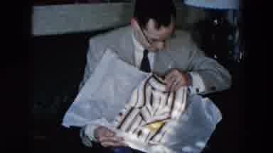 Hicksville New York (1956): Man Opening A Shirt From A Box And A Girl Washing Some