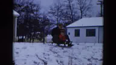 Hicksville New York (1956): A Child Waving While Riding A Sled With His Father
