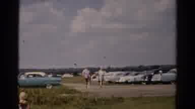 Catskill New York (1957): Men Carry Grey Ice Chest To Green Field On A Sunny Day