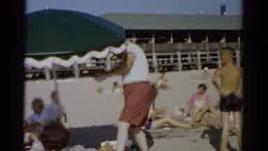 Catskill New York (1957): Man In White T-Shirt Red Shorts Adjusting Green Umbrella