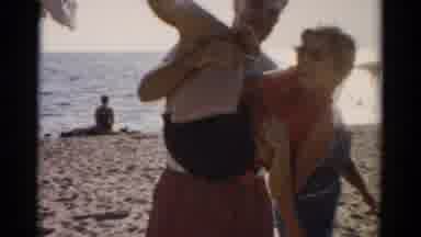 Catskill New York (1957): People Playing At The Beach And A Man Picks Up A Woman