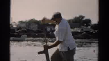 CATSKILL NEW YORK-1957: Man Pumping Water On A Boat While Another Man Inspects
