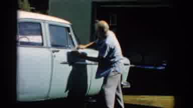 Catskill New York (1957): In Front Of A Building An Older Male Wipes A Vehicle