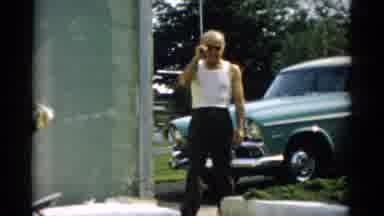 CATSKILL NEW YORK-1957: Older Gentleman Wearing White Sleeveless Tee Shirt Walking Near Green Car
