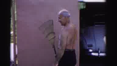 Catskill New York (1957): Man Wearing Brown Pants Holds Garden Rake On A Sunny Day