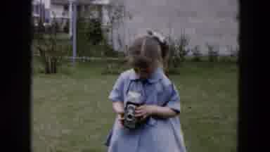 Hicksville New York (1957): Girl Wearing Blue Dress Walks To Camera Blowing Kisses
