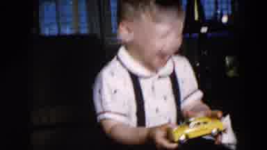 Hicksville New York (1957): Happy Young Boy Holding Yellow Toy Car; Boy Sits On