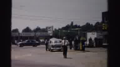 Normal Illinois USA (1957): Man Wearing White Shirt Walks From Gas Station On A