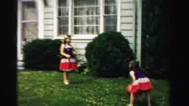 Normal Illinois USA (1957): Two Young Girls Wearing Matching Dresses Playing Catch