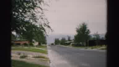 Normal Illinois USA (1957): Woman Wearing Black Skirt Sits In Grey Chair On Front