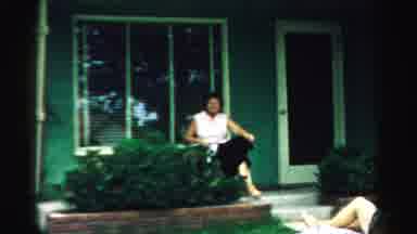 Normal Illinois USA (1957): A Dog Is Playing With A Man And A Woman Relaxing In