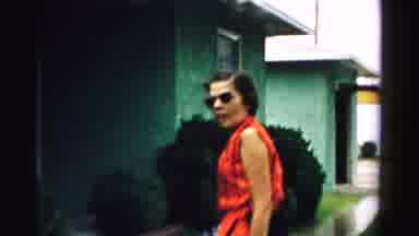 Normal Illinois USA (1957): Woman Wearing Red Shirt Sits Next To Person Wearing