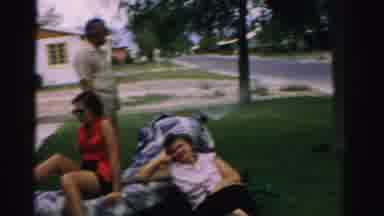 Normal Illinois USA (1957): Man Standing Behind Two Women Looks To His Left And