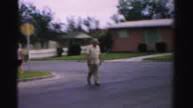 Normal Illinois USA (1957): Man Leaving Bus Stop Walking Across The Street In The