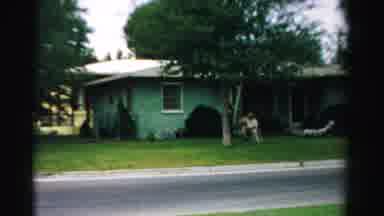 Normal Illinois USA (1957): Woman Wearing Black Dress Walks Toward Person Sitting