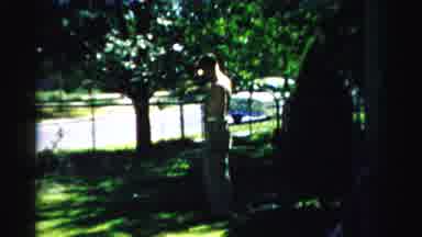NORMAL ILLINOIS USA-1957: Elder Man And Woman Sit In The Shade And Watch Younger