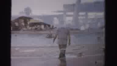 Las Vegas Nevada (1957): Man Wearing White Shirt Walks On Beach On A Clear Day