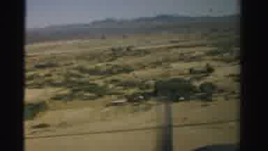 Nevada USA (1957): Outside An Airplane Window Flat Farmland Leads To Mountains Far