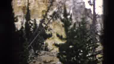 Yellowstone Wyoming USA (1958): A Rock Cliff Rises To A Mountain Peak From A Slope