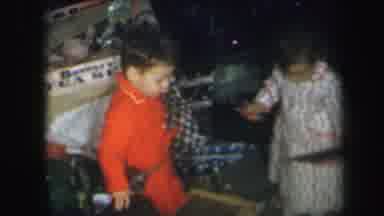 Lynbrook New York (1971): Two Children Walk Around Open Christmas Presents While A