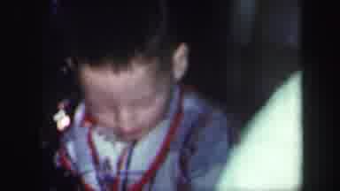 LYNBROOK NEW YORK-1971: Little Boy In Plaid Robe Plays With Something In Front