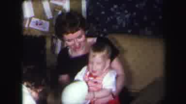 Lynbrook New York (1971): A Woman Holding Her Child Opening Christmas Presents