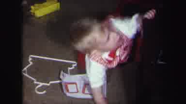 Lynbrook New York-1971: Baby Wearing Red Pants Uses Wooden Table To Stand Up