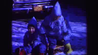 Lynbrook New York-1971: Three Children In Winter Clothes Sit On A Sled Then