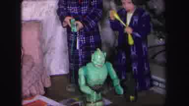 Lynbrook New York (1971): Boys Wearing Blue Robes Play With Green Robot Next To
