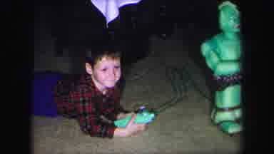 Lynbrook New York (1971): A Boy Dressed In A Plaid Shirt Lays On A Floor And Plays