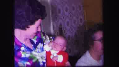 Lynbrook New York (1971): Woman Holds Sleeping Baby Wearing Red Pajamas While Boy