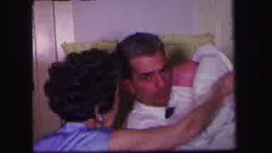 Lynbrook New York (1971): Man Is Holding Crying Baby While Older Woman Takes A