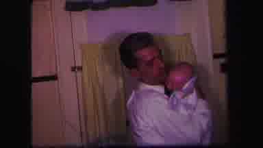 Lynbrook New York (1971): Dad Holding A Crying Baby While Mom Makes A Bottle