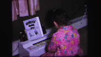 Lynbrook New York (1971): Girl Wearing Pink Pajamas Plays With Miniature Toy Music