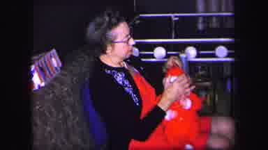 Lynbrook New York-1971: Grandma Fixes Baby's Santa Hat And Rocks Baby On Her