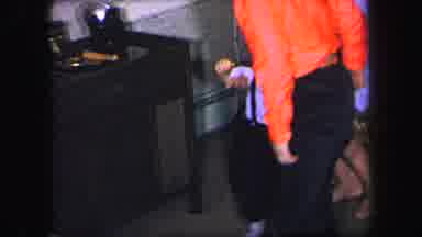 Lynbrook New York (1971): Woman Wearing Purple Dress Helps Toddler Wearing Blue