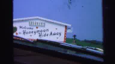 LYNBROOK NEW YORK-1971: Driving By A Large White Sign That Says Honeymoon Hide-Away