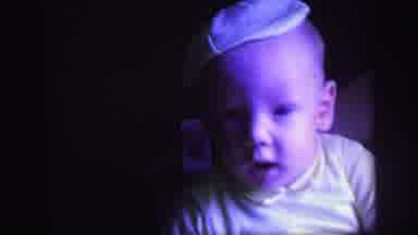 Lynbrook New York (1971): A Happy Baby Playing Alone While Sitting On Adult Lap