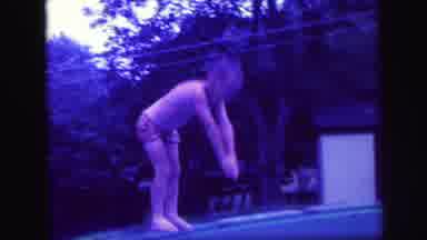 LYNBROOK NEW YORK-1971: Boy Jumps Into Pool As Girl Splashes In Water