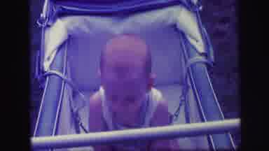 Lynbrook New York (1971): A Bald Baby Bouncing Adorably In A Carriage And Smiling
